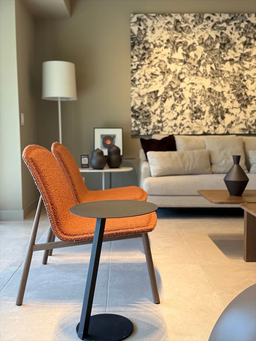 Sillón tapizado color terracota junto a mesa auxiliar en living de diseño